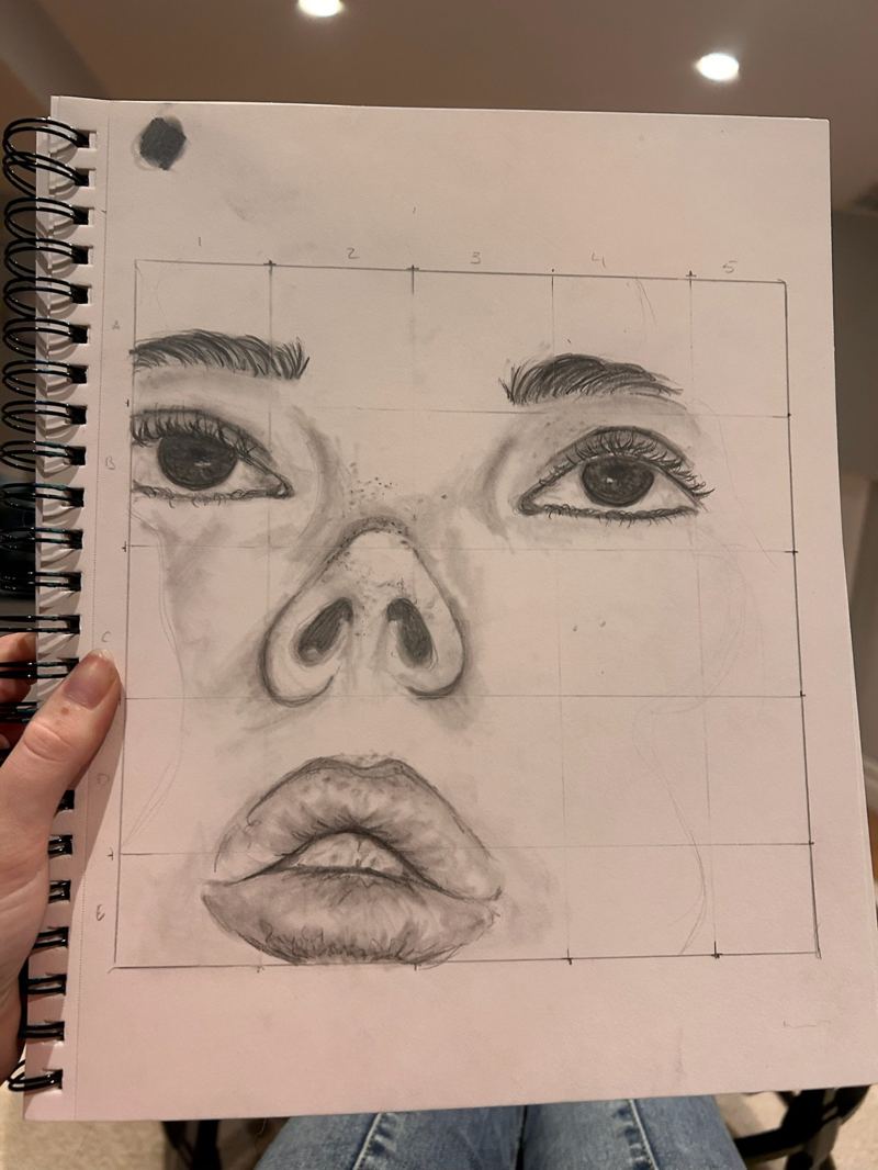 Pencil sketch of eyes, nose, and lips in a sketchbook